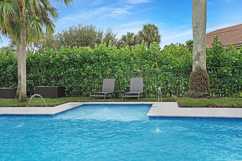 Backyard pool with water jets and lounge chairs