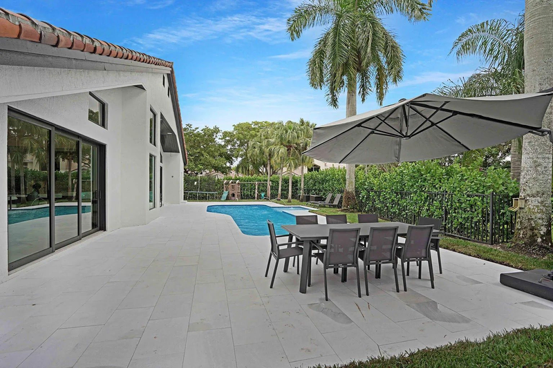 Modern home patio with pool and palm trees outdoor table