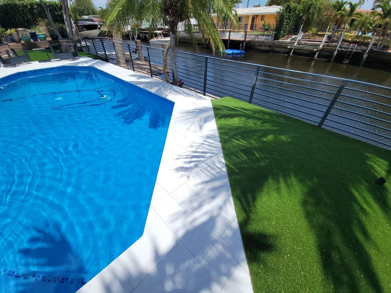 Canalfront pool with palm trees and green lawn