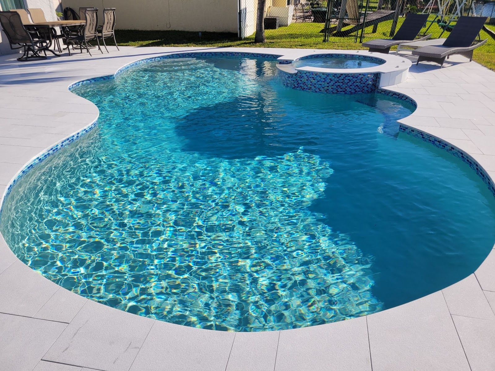Poolside Renos custom curved pool with spa and patio