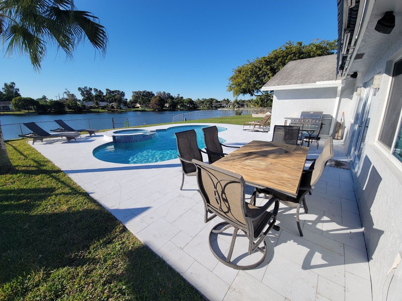 Backyard patio with pool, lake view and outdoor dining set