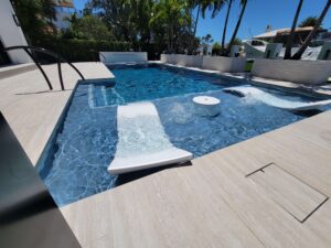 Modern luxury pool with in-water loungers and tropical patio