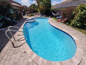 Backyard swimming pool with paver patio and ladder