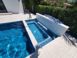 Backyard swimming pool with paver patio and lounge chairs